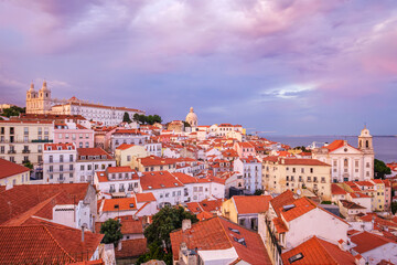 Fototapeta na wymiar View of Lisbon famous view from Miradouro de Santa Luzia tourist viewpoint over Alfama old city district on sunset with dramatic overcast sky. Lisbon, Portugal.
