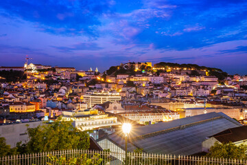 View of Lisbon famous view from Miradouro de Sao Pedro de Alcantara tourist viewpoint in the evening. Lisbon, Portugal. Camera pan