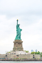 Fototapeta premium New York, New York, United States. August 07, 2023. Dramatic and detailed image of the Statue of Liberty with strong shades of green, sky with many clouds and very high resolution.