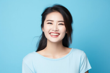Smiling Asian Woman with a Cute Portrait on Blue Studio Background