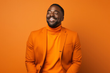 Obraz premium Smiling African American Man with Vibrant Orange Studio Background