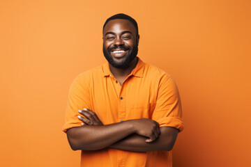 Obraz premium Smiling African American Man with Vibrant Orange Studio Background
