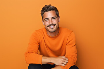 Cheerful Caucasian Man with a Charming Smile on Vibrant Orange Studio Background