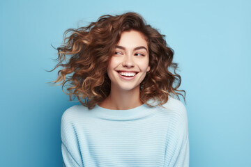 Fototapeta premium Joyful Caucasian Woman with Radiant Smile on Vibrant Blue Studio Background