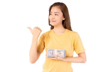 Happy young asian woman holding money dollars banknotes and pointing to space isolated over yellow background Happy asian lady hold money dollars and Smiling girl earning a lot of money or win lottery