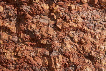 Close up shot of rock surface, details of sand stone texture. Light brown rock texture. Mountain rough surface. Stone wall. Background, backdrop.