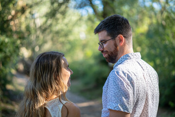 Couple in love enjoying a walk in the woods at sunset