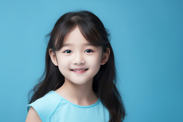Smiling Asian Girl with Blue Studio Background