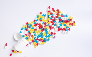 Assorted pharmaceutical medicine pills and capsules and bottle on white background. Copy space for text. 
