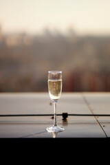 A glass of white wine against the sunset sky.
