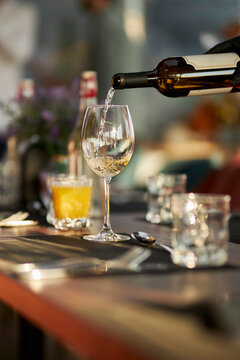 The waiter pours white wine into a glass. Soft focus. luxury living concept. Restaurant. 