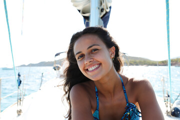 Cute young girl looking at the camera while having her photo taken on a sailing boat
