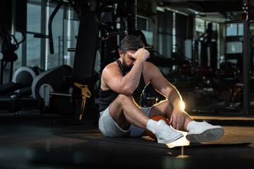 depress athletic caucasian man after practicing routine weightlifting and overtraining at modern gym, active fitness people suffer pain injury accident from workout weight training in dark sport club