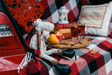 Two glasses of mulled wine on a wooden board against the background of a burning candle