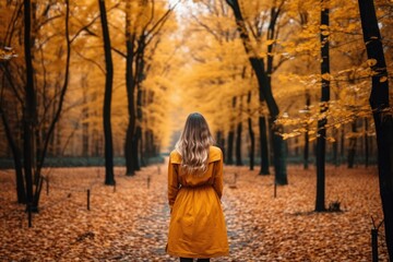 Practices for womens wellness in autumn. Womens spiritual, mental, and physical health at autumn fall season. Back view of woman at yellow trench coat on autumn nature background