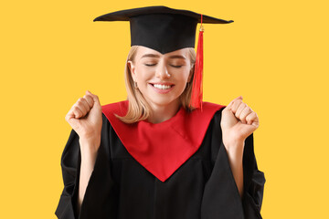 Happy female graduate student on yellow background, closeup