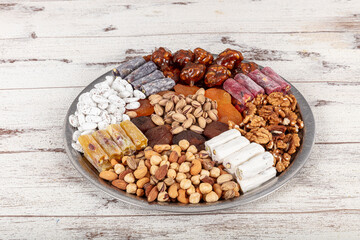Mixed Nuts. Various nuts, pistachios, almonds, Turkish delight and assorted cookies on a copper tray, view from above.