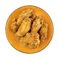 Fried chicken wings on a orange plate isolated on white, top view