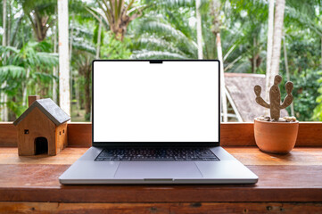 Blank screen of Laptop computer on wooden table with garden view