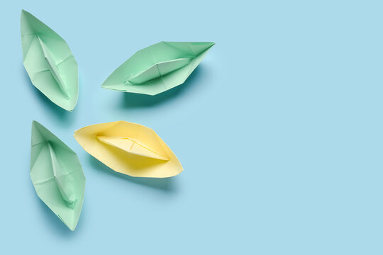 Colorful origami boats on blue background