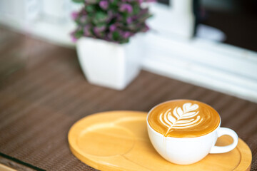 coffee pattern in a white cup on a wooden tray