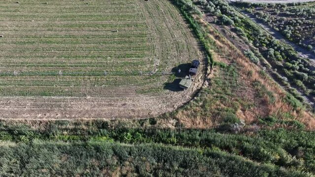 Aerial farmer loads hay into truck trailer agriculture 1. Farming community agricultural economy. Summer harvesting of alfalfa hay agriculture. Tractor equipment, Seasonal rural farm harvest.
