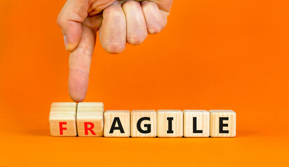 Agile or fragile symbol. Concept words Agile and Fragile on wooden cubes. Beautiful orange table orange background. Businessman hand. Business agile and fragile concept. Copy space.