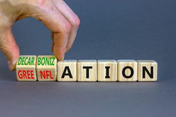 Decarbonization or greenflation symbol. Concept words Decarbonization Greenflation on cubes. Beautiful grey background. Businessman hand. Business decarbonization greenflation concept. Copy space.