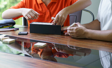 Asian father and son playing wood blocks game Carefree kid playing wood blocks game building constructor from blocks with father at home