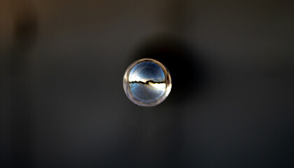 Gray soap bubble on a blurred dark background. Close-up.