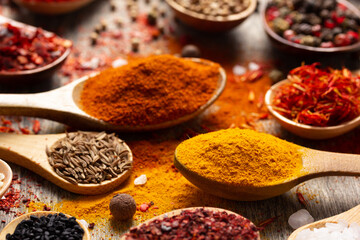 Paprika, pepper and turmeric spice in spoon at table background. Variety of spices and ingredients