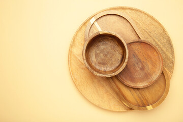 Different wooden plate and trays on beige background