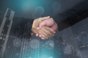 Businessmen shaking hands. Abstract city in the background. Collaboration or teamwork concept.