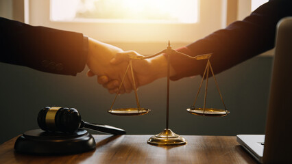 Businessman shaking hands to seal a deal with his partner lawyers or attorneys discussing a...