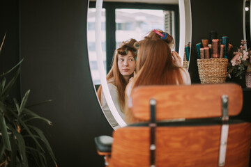 Girl looking at the mirror in the hair salon