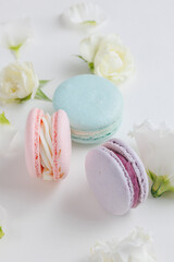 Beautiful Set colorful French macaroons and flowers. Flat lay, top view, spring white background. Concept celebration gift
