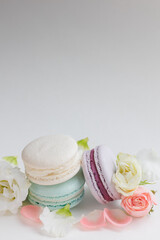 Beautiful Set colorful French macaroons and flowers. Flat lay, top view, spring white background. Concept celebration gift