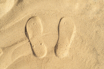 Texture background footprints of human feet on the sand  on the beach