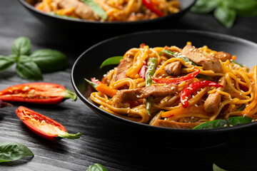 Stir fry chow mein noodles with pork and vegetable in black bowl. asian style food