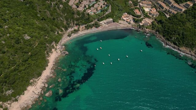 Drone footage of boats gently swaying in the sunny sea, moored not far from the Paralia Ermones Beach, on a hot day