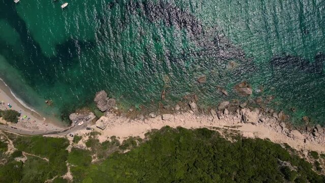 Drone footage of boats gently swaying in the sunny sea, moored not far from the Paralia Ermones Beach, on a hot day