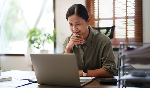 Close Up Woman Working On Laptop And Using Mobile Phone In Office..