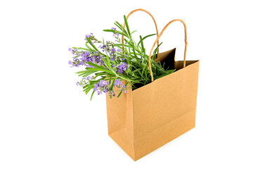 Bouquet of lavender flowers in paper bag isolated on white .