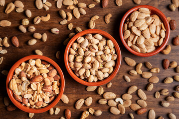 Bowls with almonds, pistachios and roasted nuts, top view.