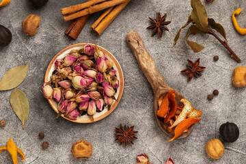 Various spices: damask rose, cinnamon, dried lime, orange peel, bay leaf, star anise. Top view.