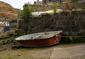 Fototapeta na wymiar Close up of a small fibreglass boat beached in the River Esk at low tide