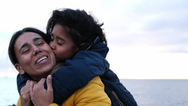 4k video of mother and daughters hugging and giving each other a very affectionate kiss. Concept: motherhood, happiness, love