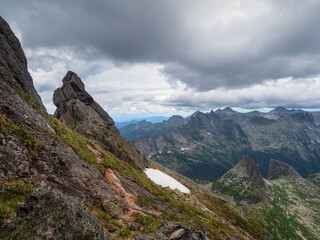 Pointed cliffs mountainside. Ghost rocks. Awesome scenic mountain landscape with big cracked pointed stones in misty rainy morning. Sharp rocks background.