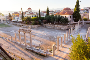 View od the ruins of the Greek Agora in the Plaka of the city of Athens, Greece, at dusk during a sunny summer day - obrazy, fototapety, plakaty