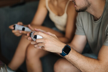 Middle selection of couple using video game joysticks gamepad and playing